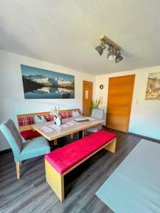 a living room with a table and a red bench at Landhaus Maria in Hippach +13 photos