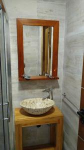 a bathroom with a sink and a mirror on a table at Los Maquis e Inacayal in Villa La Angostura