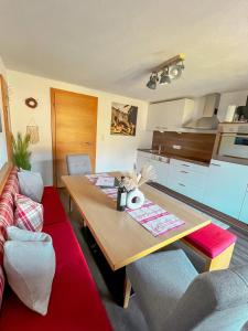 a living room with a wooden table and a kitchen at Landhaus Maria in Hippach