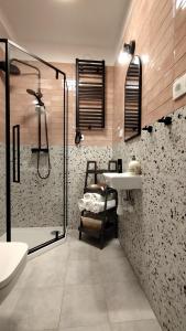 La salle de bains est pourvue d'une douche et d'un lavabo. dans l'établissement Domki na polance, à Horyniec