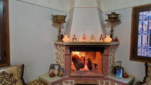 a living room with a fireplace with chickens in it at HôteL Berbère de la Montagne in Imdiazene