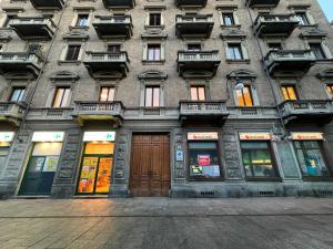 een hoog gebouw met ramen en deuren aan een straat bij La Madama Cristina in Turijn