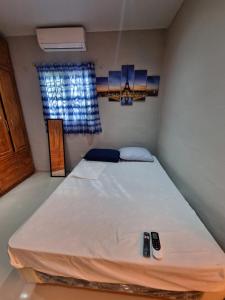 a bed in a room with two remote controls at Casa para descanso familiar in San Pedro Masahuat