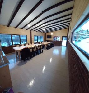 uma grande sala de jantar com uma mesa longa e cadeiras em Pensiunea Auras em Dorna Arini