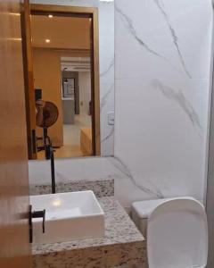 a bathroom with a sink and a toilet and a mirror at Suites Phison in Cabo Frio