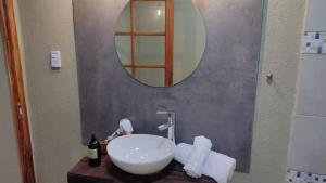 uma casa de banho com um lavatório branco e um espelho. em La Genoveva Posada entre Viñedos em Villa Unión