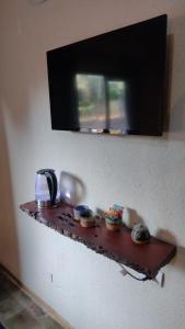 uma prateleira numa parede com uma televisão por cima em La Genoveva Posada entre Viñedos em Villa Unión