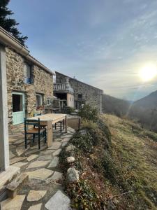 uma casa de pedra com uma mesa de piquenique em frente em Mas Caraus em Montferrer