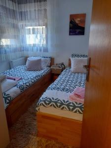 2 łóżka pojedyncze w pokoju z drzwiami w obiekcie Apartman Royal Vlašić w mieście Vlašić