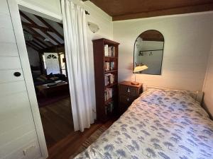 1 dormitorio con cama y espejo en Luxury Cabin Bawley Ridge Farm, dog friendly en Termeil