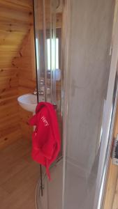 a red jacket sitting on a stool in a shower at Glamping Pod Thady Killynick County Fermanagh in Killyhevlin