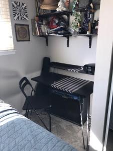 Cette chambre comprend un bureau avec une chaise et un lit. dans l'établissement Homestay - 5-Star Hostess with Upstairs Room in SJC, à San Juan Capistrano