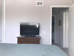 telewizor z płaskim ekranem siedzący na komodzie w sypialni w obiekcie Homestay - 5-Star Hostess with Upstairs Room in SJC w mieście San Juan Capistrano