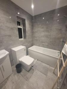 une salle de bain avec toilettes, baignoire et lavabo dans l'établissement New 4 bedrm house! Parking. 10min to City / Etihad, à Manchester