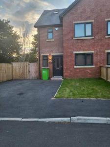 a brick house with a driveway in front of it at New 4 bedrm house! Parking. 10min to City / Etihad in Manchester