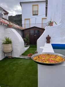 a pizza sitting on a table in a backyard at Casa rural El Patio con chimenea, barbacoa, piscina, patios exteriores para sus mascotas de manera gratuita in Benadalid