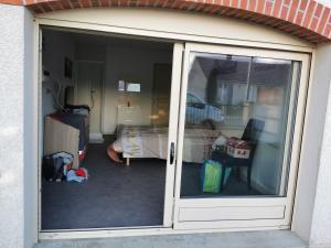 een glazen schuifdeur van een kamer met een slaapkamer bij Gîte 12 couchages in Vailly-sur-Sauldre