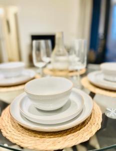 a table with plates and bowls on top of it at High-Spec Skyline Apartment in London - 2 BDR & Balcony in London