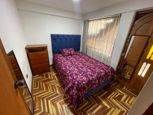 - une chambre avec un lit et une couette violette dans l'établissement the traveler's house "Airb nb and travel", à Cusco