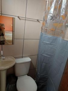 y baño con aseo y cortina de ducha. en Casa Grande Aconchegante en Alter do Chao