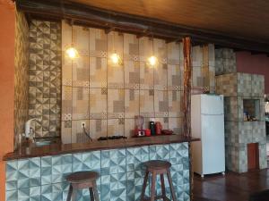 cocina con encimera con taburetes y nevera en Casa Grande Aconchegante en Alter do Chao