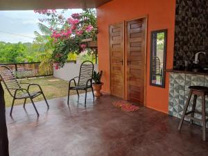 a patio with two chairs and a wooden door at Casa Com bilhar 4 quartos alter in Alter do Chao