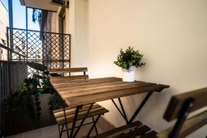 einem Holztisch mit Topfpflanze auf dem Balkon in der Unterkunft La Grande Bellezza in Neapel