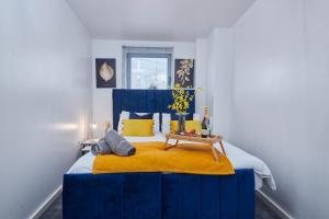 1 dormitorio con cama azul y manta amarilla en Spacious 4 Beds Apt - Perfect for Families, Contractors & FREE Parking, en Leeds
