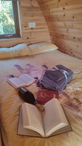 Killynick Glamping Oiney Fishing County Fermanagh في إنيسكيلين: سرير مع كتاب مفتوح وزجاجة من النبيذ