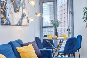 comedor con sillas azules y mesa en Spacious 4 Beds Apt - Perfect for Families, Contractors & FREE Parking, en Leeds
