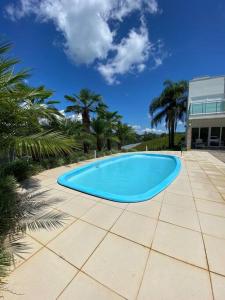 una grande piscina blu su un patio di Casa de Campo em meio a Vinhedos a Pinto Bandeira