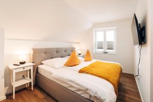 a bedroom with a large bed with a yellow blanket at Tor zur Altstadt in Husum