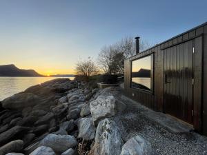 ein Haus am Ufer eines Wasserkörpers in der Unterkunft Kråen Gard in Larsnes