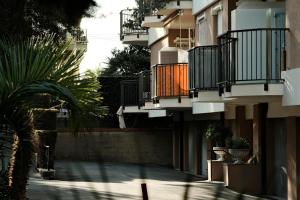 un edificio con balcones y una palmera frente a él en Appartamento a due passi dal mare, en Bordighera