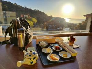 een tafel met een dienblad met eten en een zak bij 熱海温泉　実の別荘 in Atami