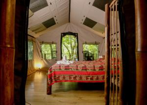 a bedroom with a bed in a tent at Rio Tico Safari Lodge in Punta Mala