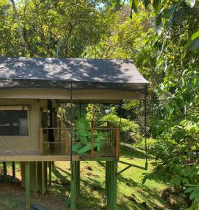 una casa con una terraza con sillas. en Rio Tico Safari Lodge en Punta Mala