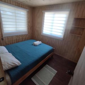 カストロにあるCabañas altos de la chacra , 2 dormitoriosの小さなベッドルーム(ベッド1台、窓2つ付)が備わります。