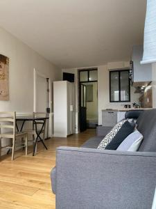 Il comprend un salon avec un canapé gris et une cuisine. dans l'établissement Lyon Standing Historic City Apartment, à Lyon