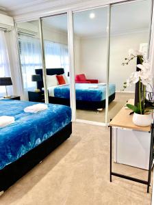 a bedroom with two beds and a mirror at North Ryde Guesthouse in Sydney