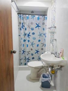 a bathroom with a toilet and a sink and a shower curtain at Santa Julia Travel in San Andrés