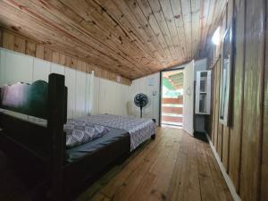 um quarto com uma cama e um tecto de madeira em Pousada e Camping do Clodo na Ilha do Mel