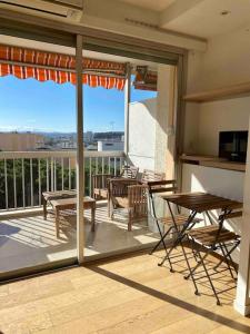 a patio with a table and chairs on a balcony at Cocon ensoleillé avec parking gratuit in Nice