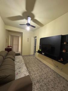 ein Wohnzimmer mit einem Sofa und einem Flachbild-TV in der Unterkunft Residencial Copacabana in Guarapari