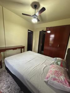 a bedroom with a bed with a ceiling fan at Residencial Copacabana in Guarapari
