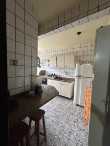 a kitchen with a white refrigerator and a table at Residencial Copacabana in Guarapari