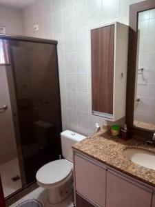 uma casa de banho com um WC, um lavatório e um chuveiro em Casa Sobrado com piscina Santa Felicidade 6 pessoa em Curitiba