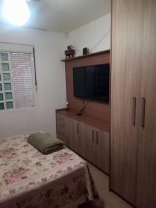 sypialnia z łóżkiem i telewizorem z płaskim ekranem w obiekcie Casa Sobrado com piscina Santa Felicidade 6 pessoa w mieście Kurytyba