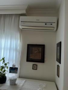 a living room with a ceiling fan and a window at Quarto privativo em casa domiciliar in Campo Grande