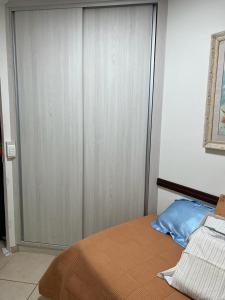 a bedroom with a bed with a wooden door at Quarto privativo em casa domiciliar in Campo Grande